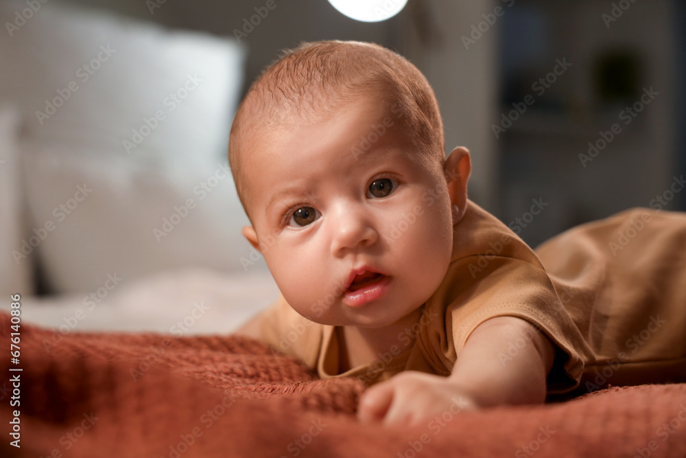 Cute little baby lying on bed at night, closeup