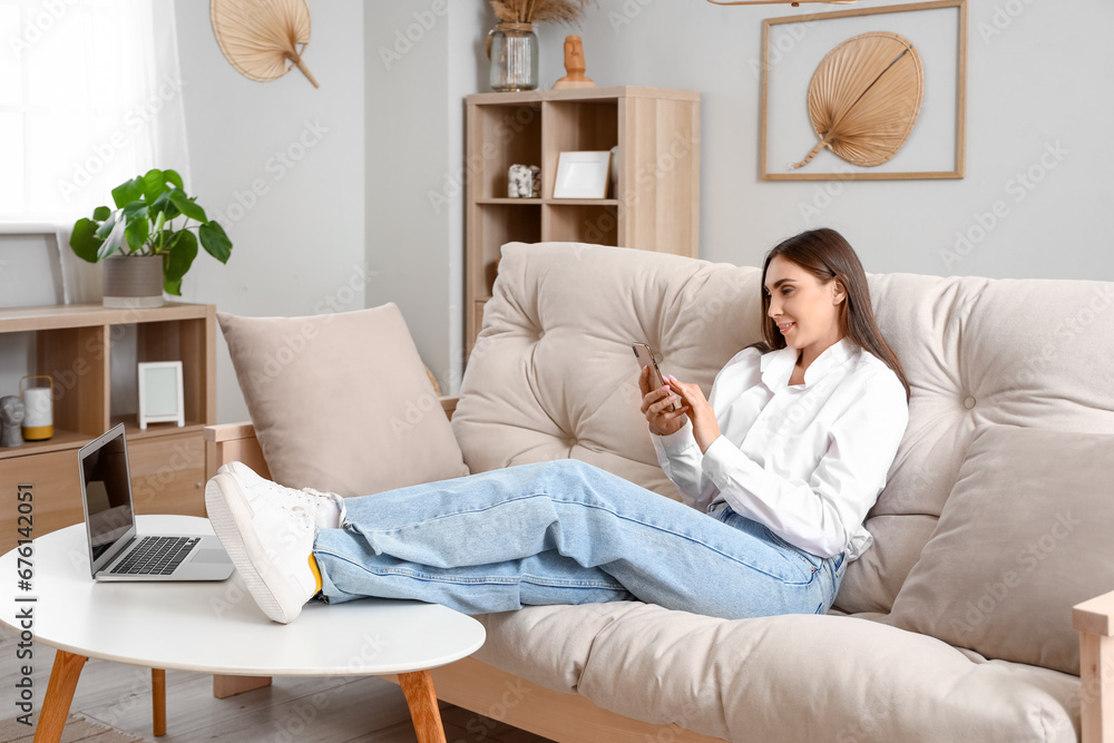 Young woman sitting on couch in living room