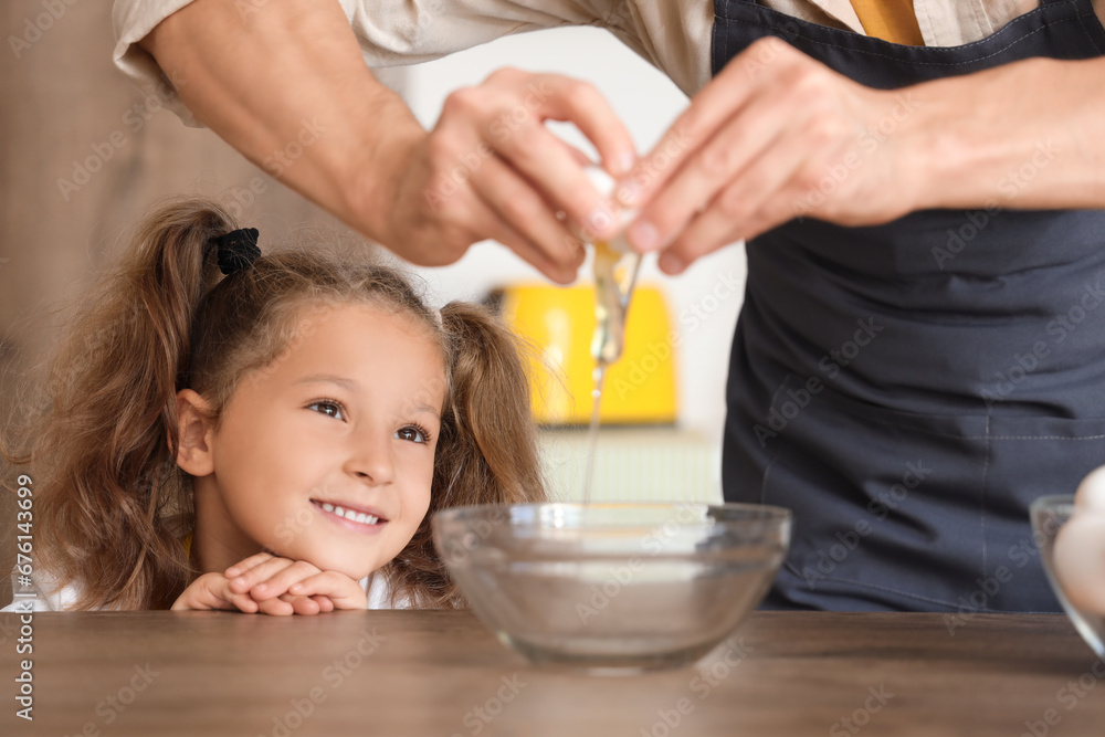 Cute little girl and her dad breaking egg in kitchen, closeup