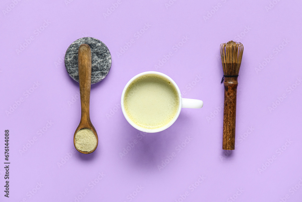 Cup of fresh matcha tea, powder and chasen on lilac background