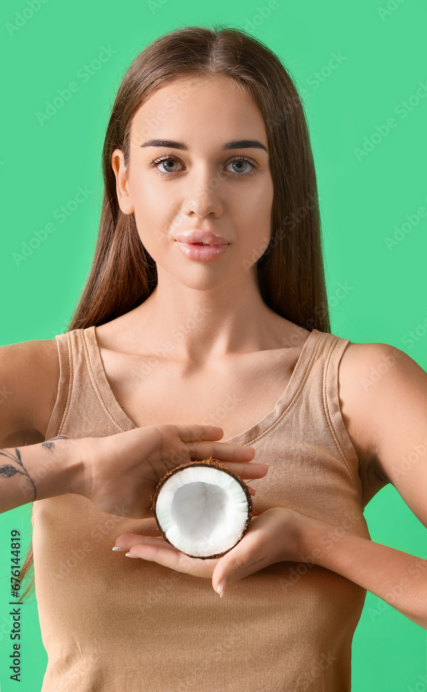 Beautiful young woman with coconut on green background, closeup