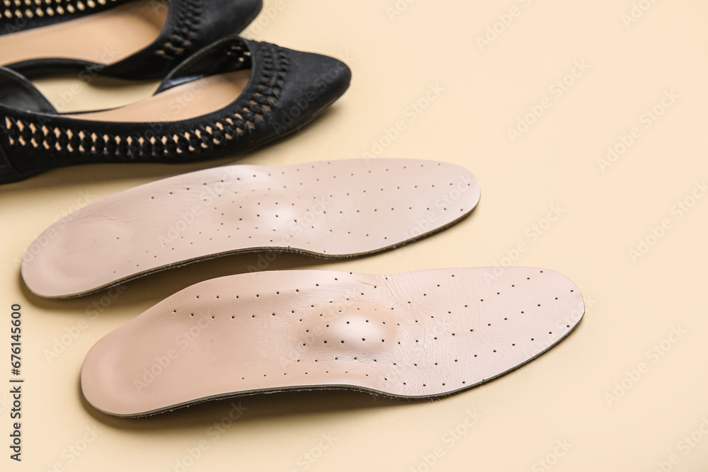 Stylish womens shoes with orthopedic insoles on beige background