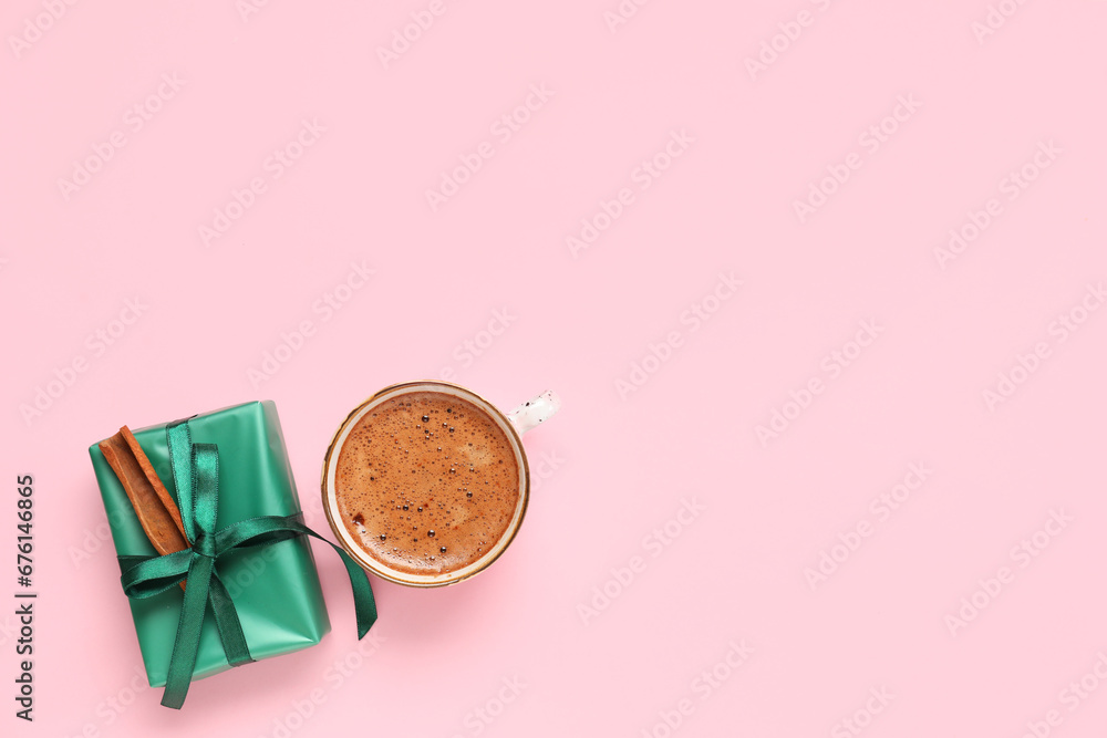 Cup of coffee and gift box on pink background