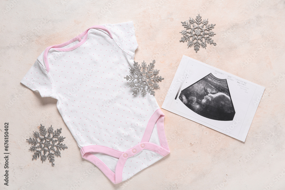 Composition with stylish baby clothes, sonogram image and Christmas decorations on light background