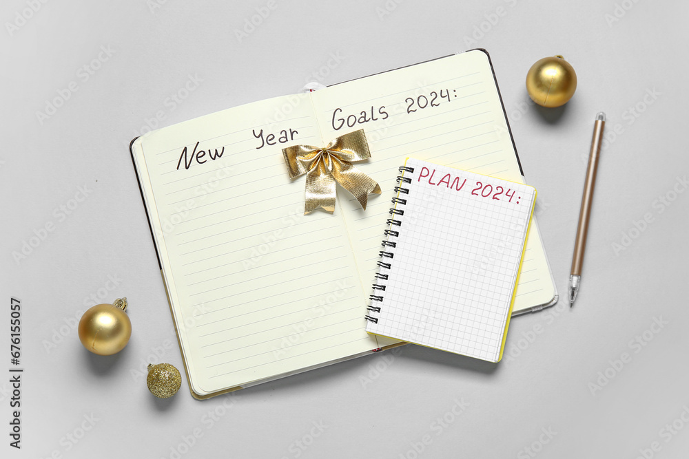 Notebooks with text NEW YEAR GOALS and PLAN 2024 on grey background