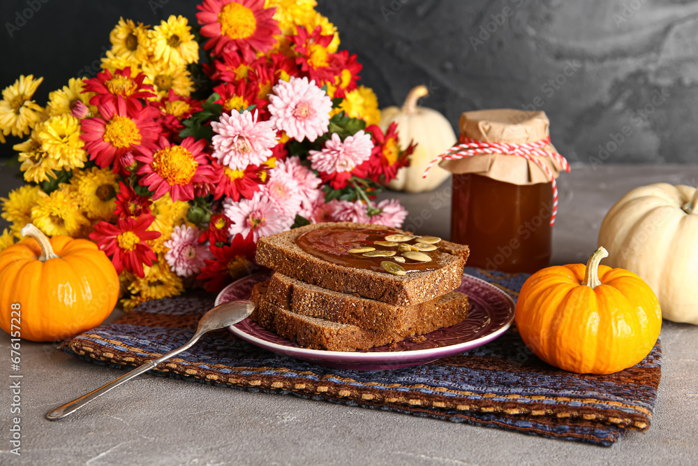 Plate of toasts with sweet pumpkin jam and seeds on grey table