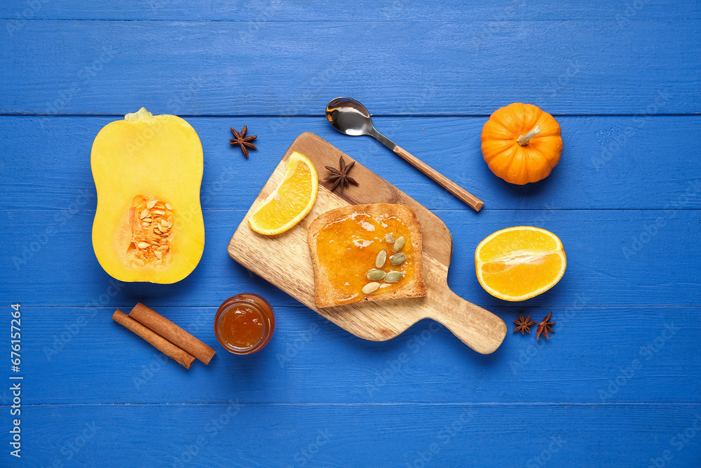 Board of toast with sweet pumpkin jam and seeds on blue wooden background