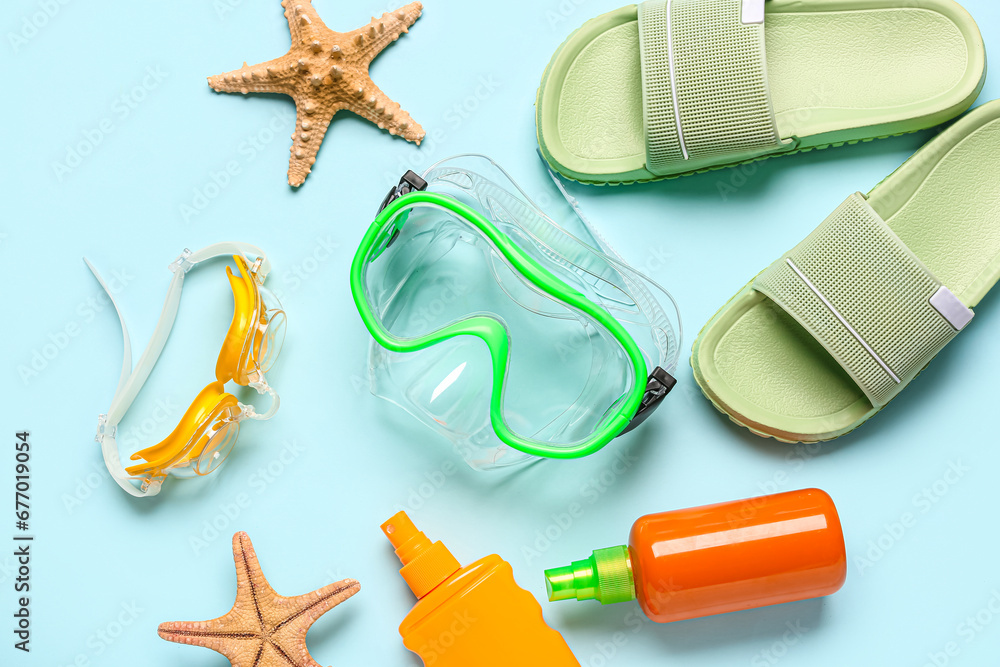 Composition with beach accessories, cosmetic products and starfishes on color background