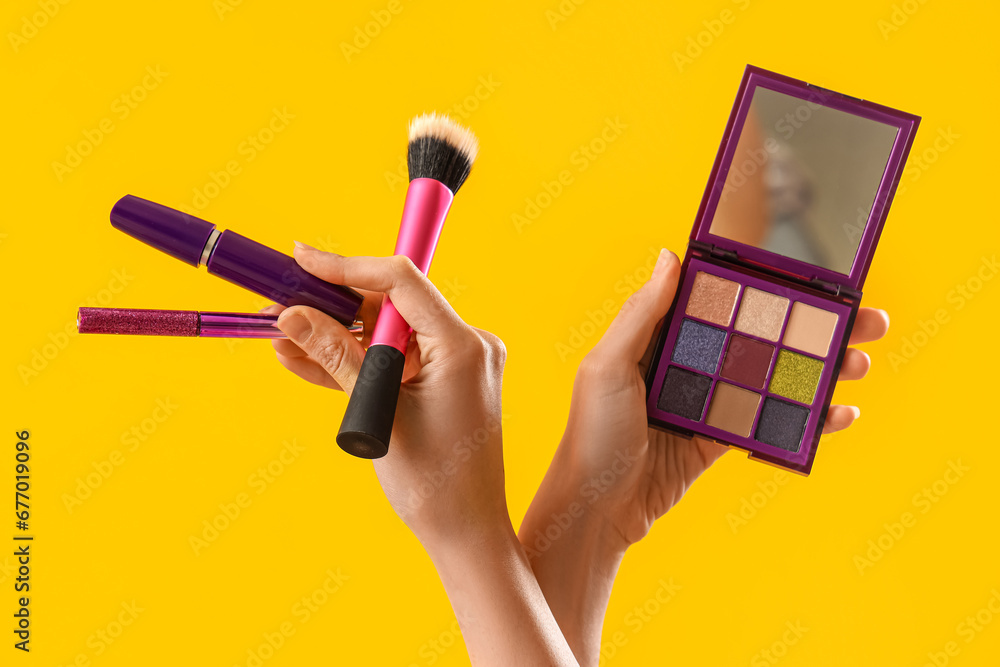 Woman with makeup products on yellow background