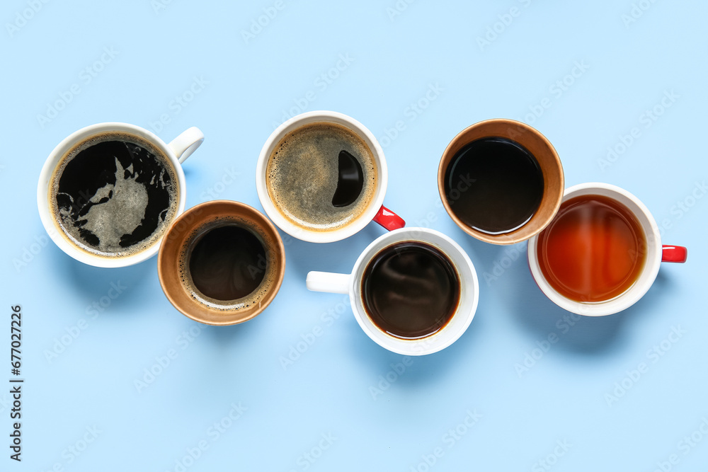 Cups of hot coffee on blue background