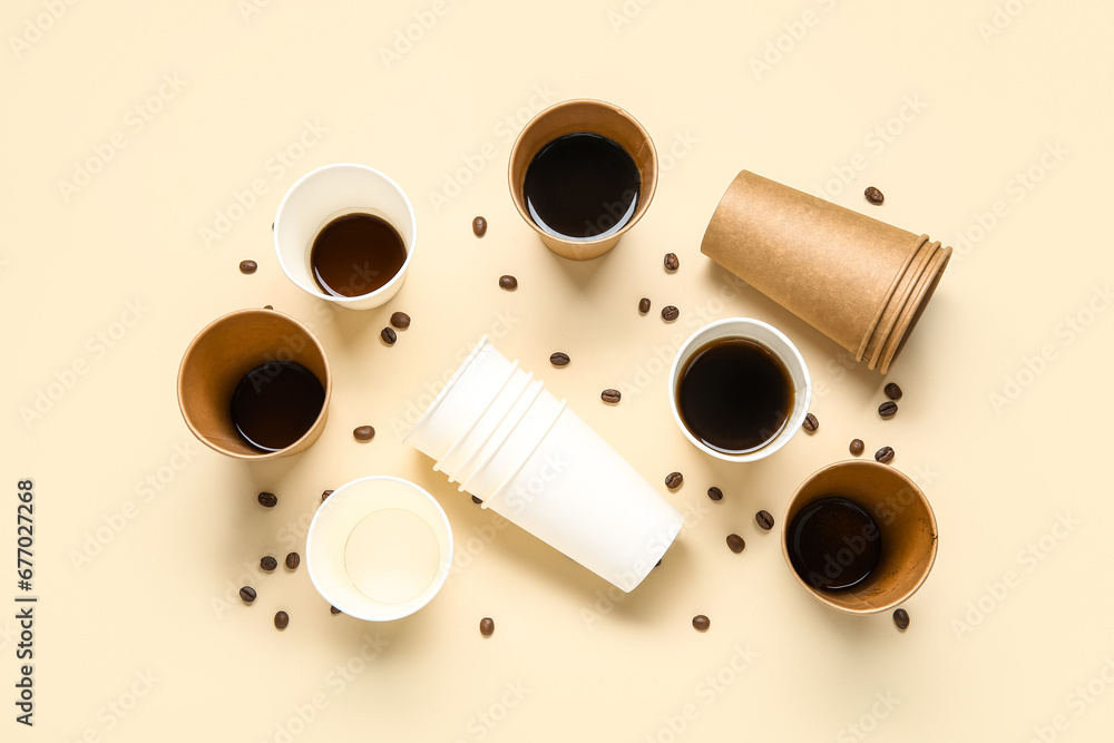 Paper cups of hot coffee and beans on beige background