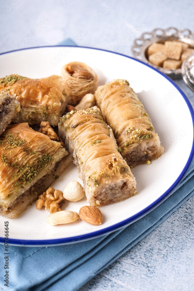 Plate with tasty baklava on light background, closeup