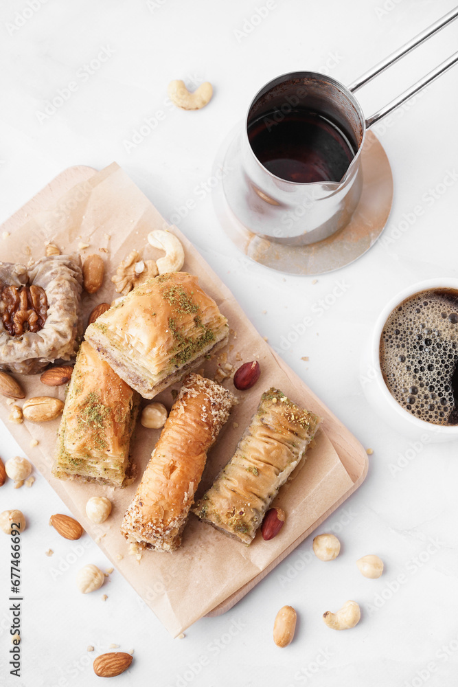 Wooden board with tasty baklava on light background