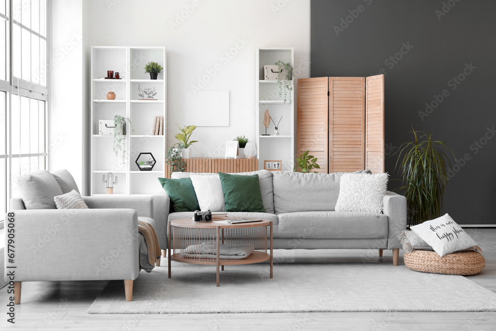 Interior of bright living room with cozy grey sofas and coffee table