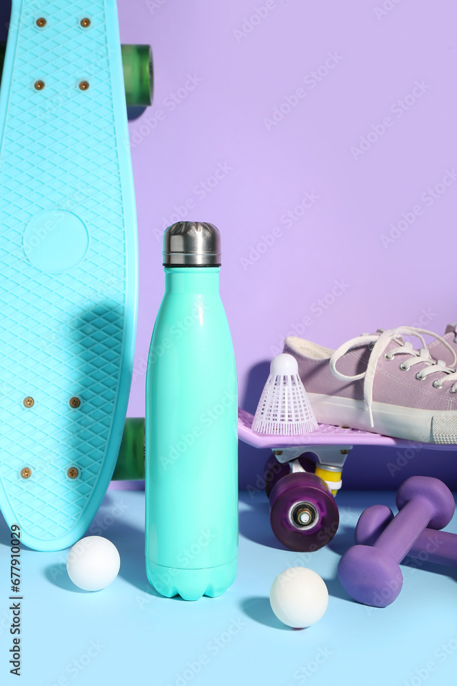 Composition with sports equipment, shoes and bottle of water on color background