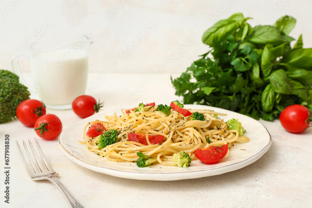 Plate of tasty pasta with broccoli and tomatoes on white background