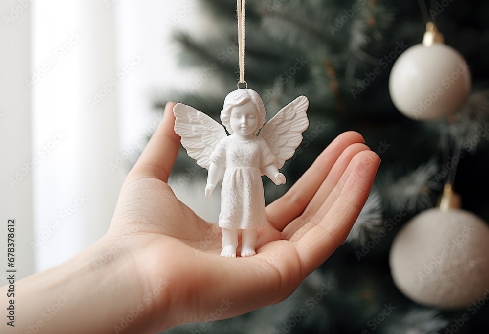 a hand is holding a little angel ornament on a christmas