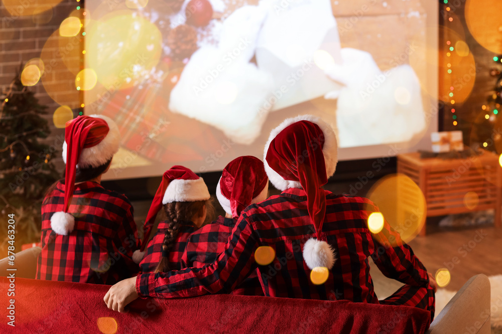 Young family watching movie at home on Christmas eve