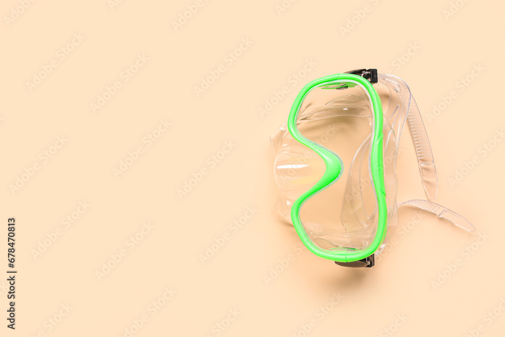 Green swimming mask on beige background