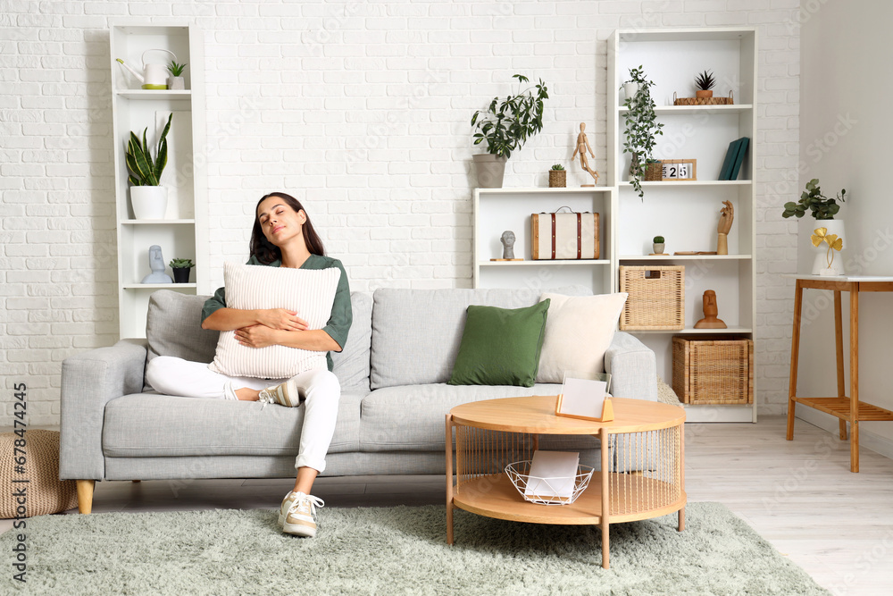 Beautiful happy young woman relaxing on sofa in living room