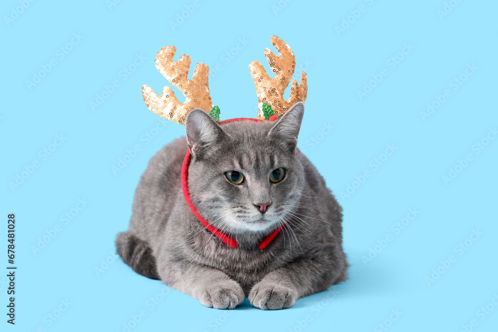 Cute cat with reindeer horns on blue background