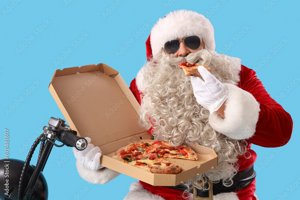 Santa Claus with tasty pizza on bike against blue background