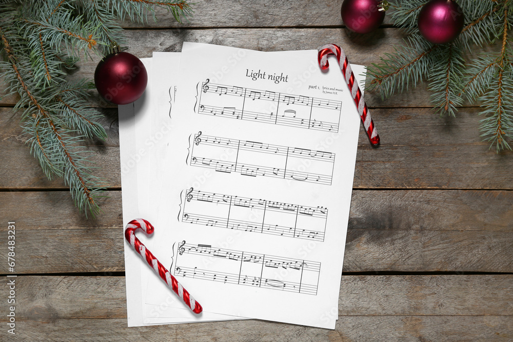 Composition with music sheets, fir branches and Christmas decorations on wooden background