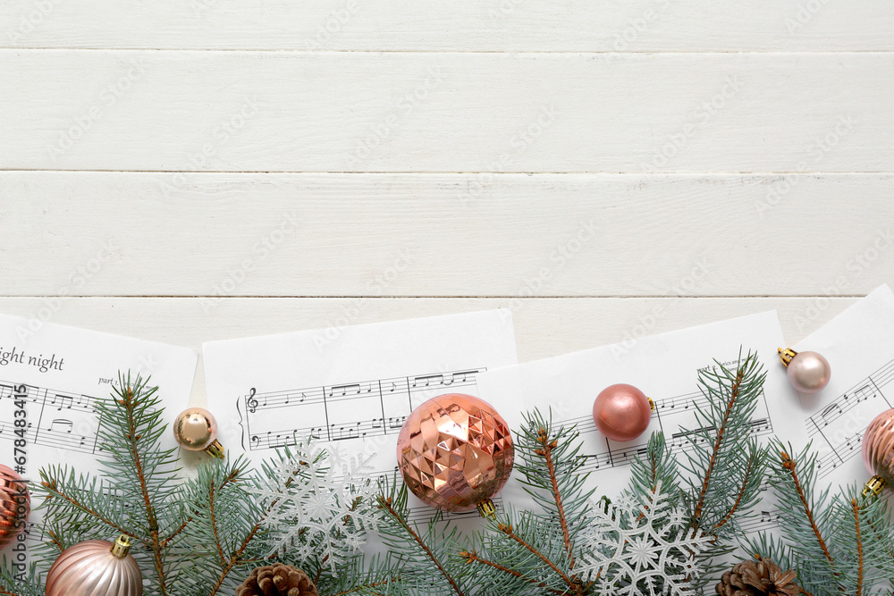 Composition with music sheets, beautiful Christmas decorations and fir branches on white wooden background