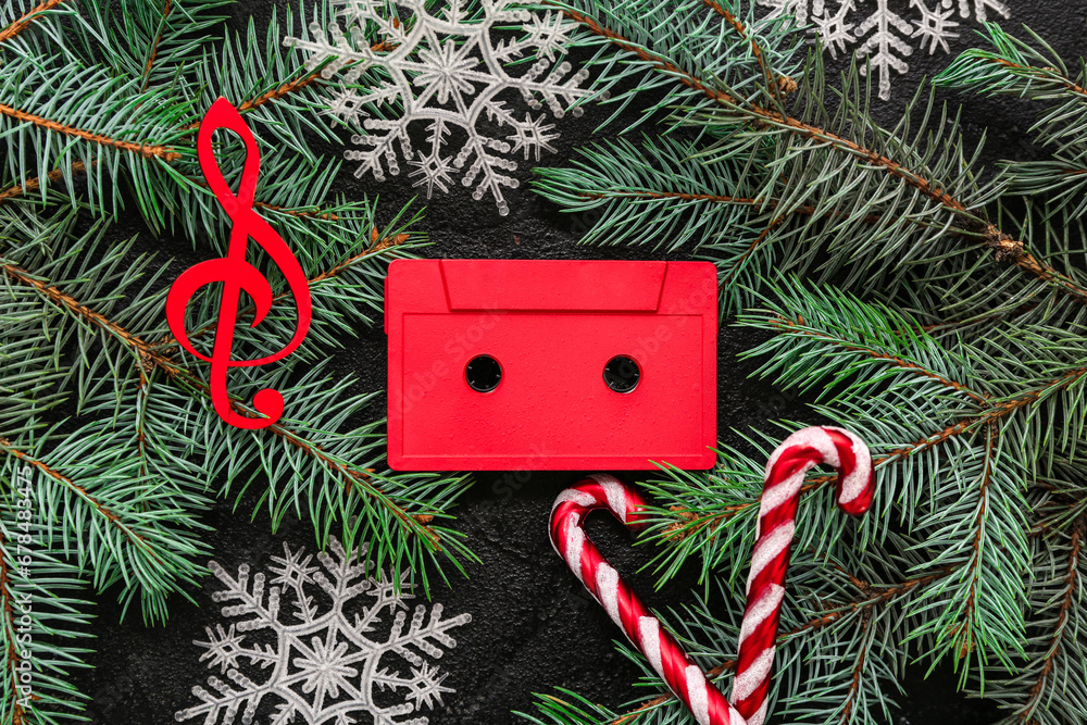 Composition with audio cassette, fir branches and Christmas decorations on dark background