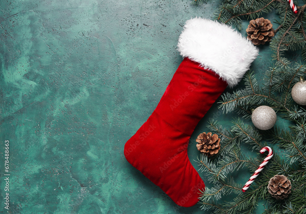 Christmas sock with fir branches and beautiful decorations on green background