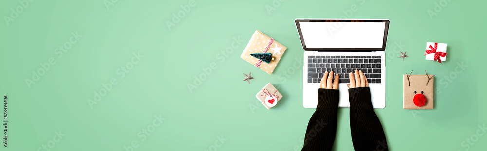 Person using a laptop computer with Christmas gift boxes from above