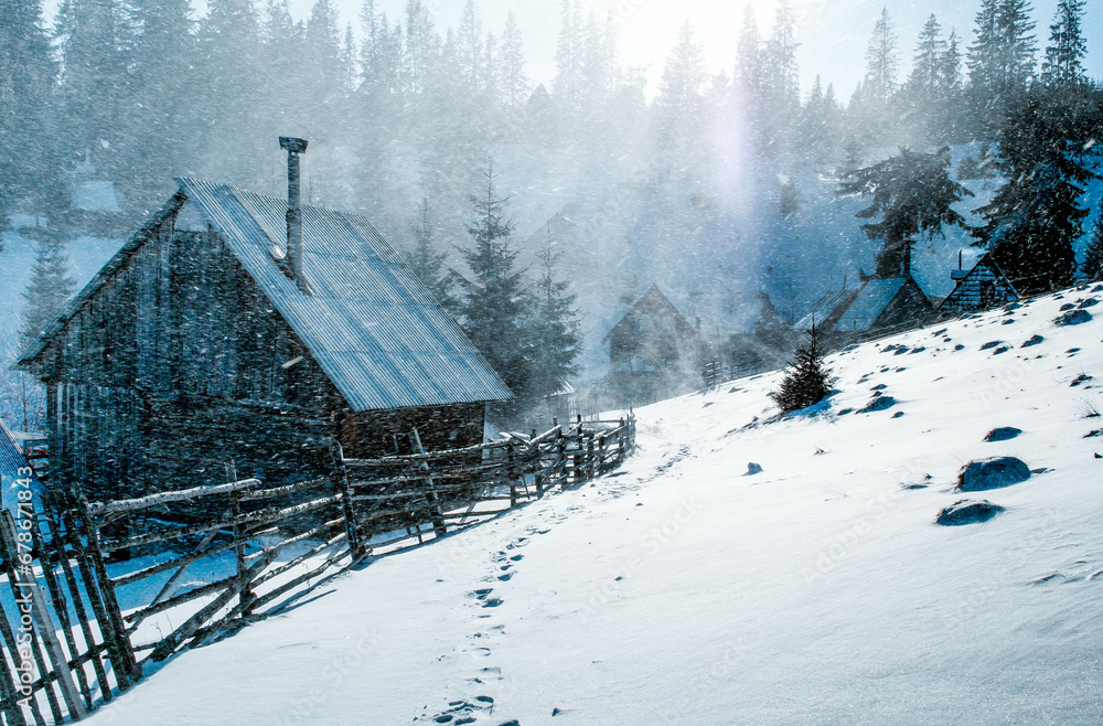 small frozen cottage in winter snowfall