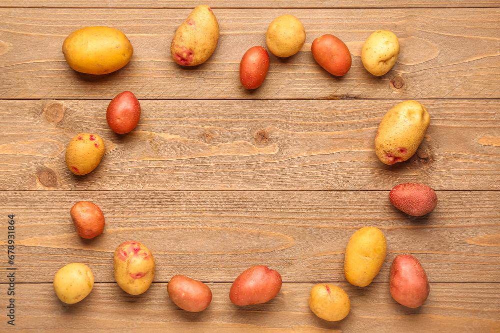 Frame made of fresh raw potatoes on wooden background