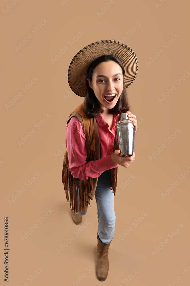 Female bartender dressed as cowgirl with shaker on beige background