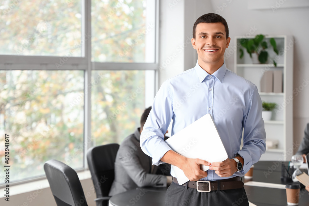 Young businessman with laptop in office