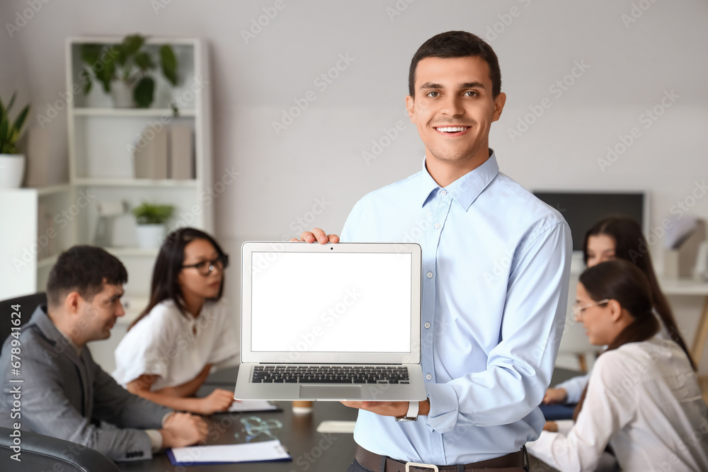 Young businessman with laptop in office