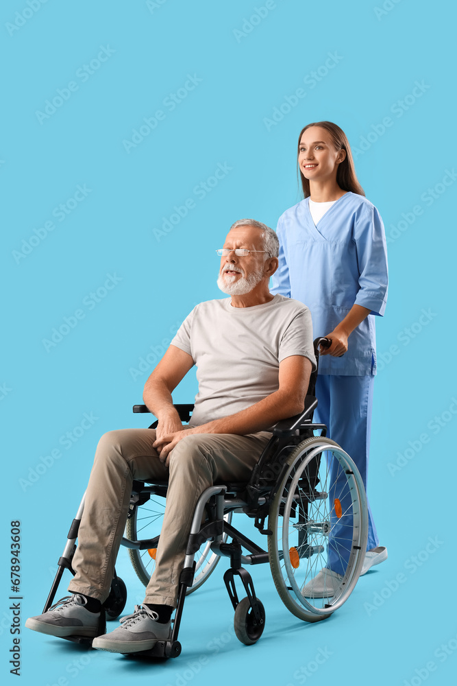 Senior man in wheelchair with nurse on blue background