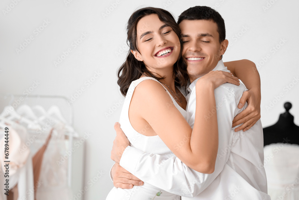 Young couple hugging while planning their wedding in office