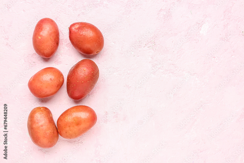 Fresh raw potatoes on pink background