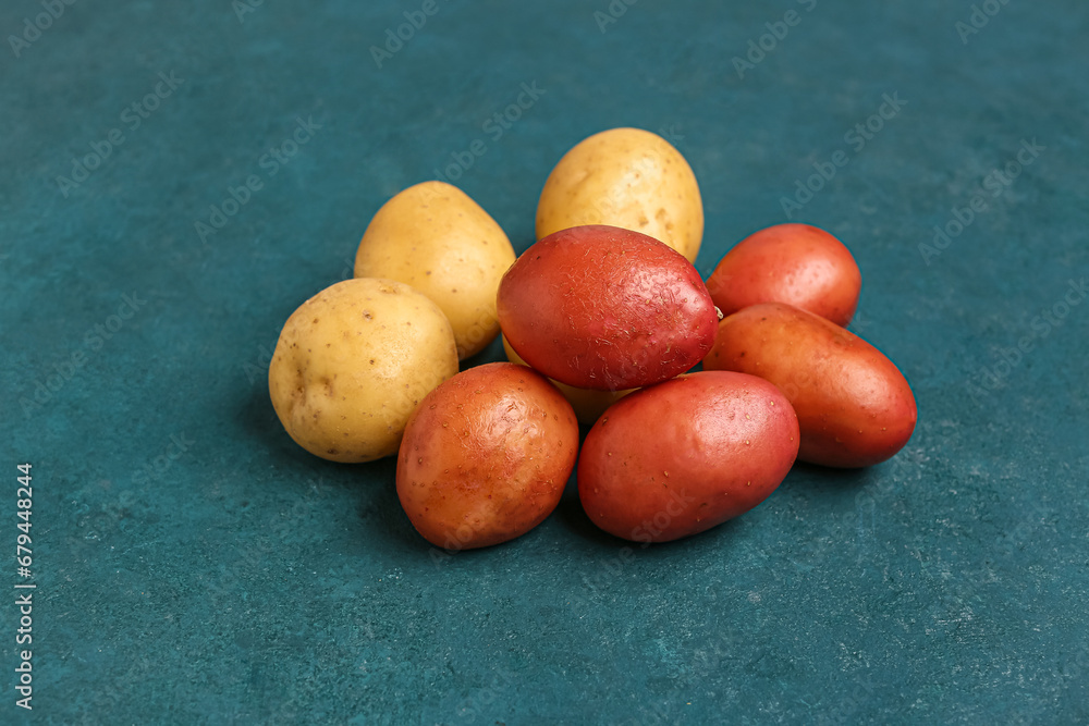 Fresh raw potatoes on blue background