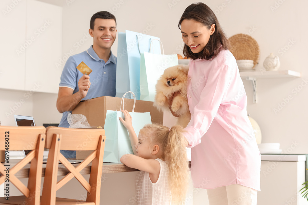 Happy family with cute dog shopping online in kitchen