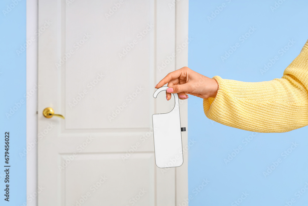 Woman with door hanger in hotel room, closeup