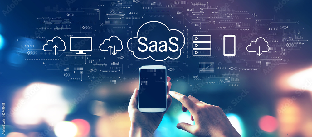 SaaS - software as a service concept with a smartphone in blurred city lights at night