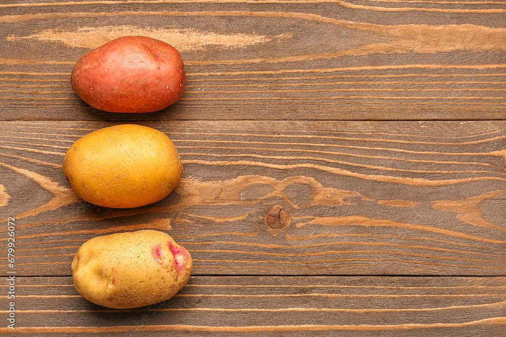 Fresh raw potatoes on wooden background