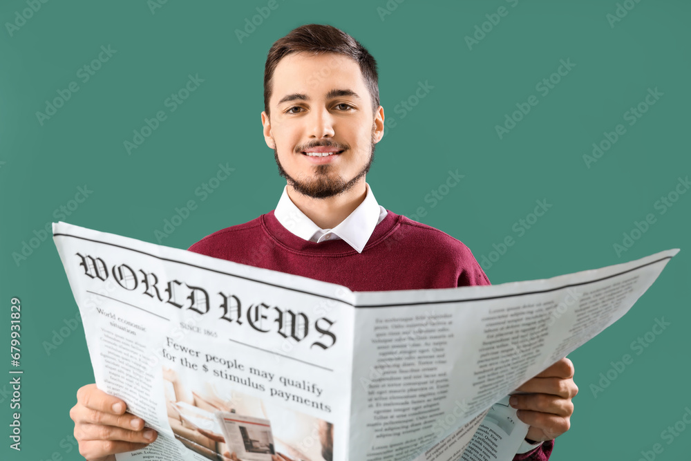 Young man reading newspaper on green background