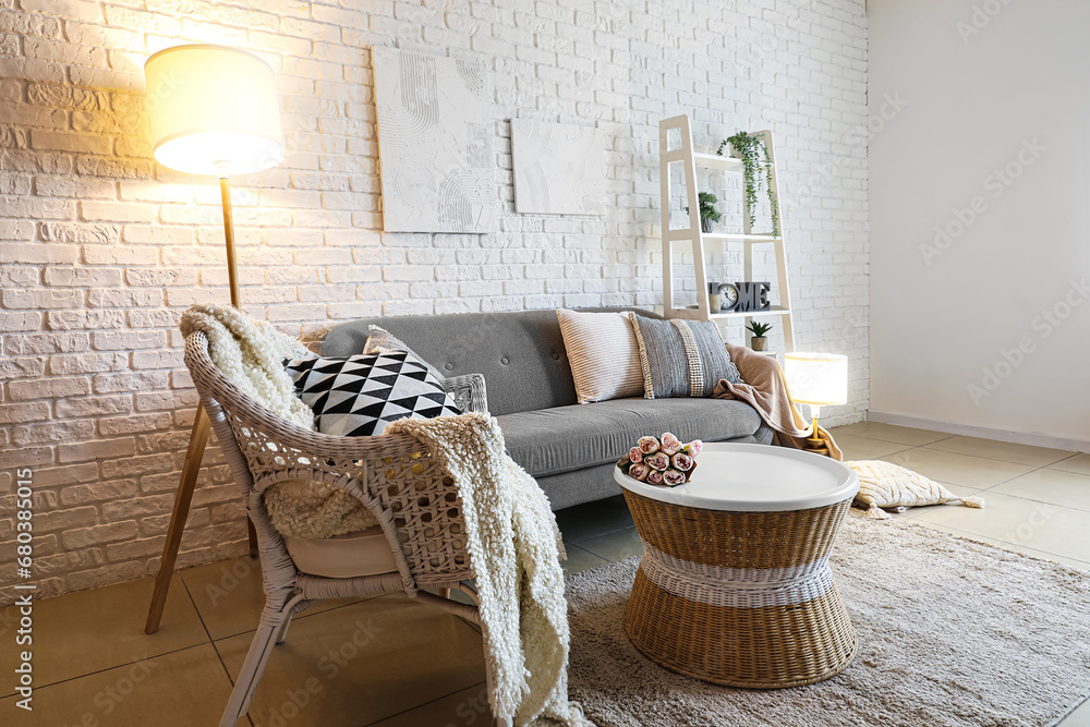 Interior of living room with cozy grey sofa and glowing lamps