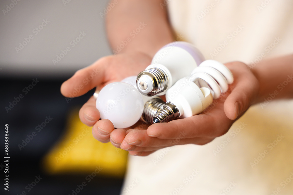 Man holding different light bulbs at home, closeup