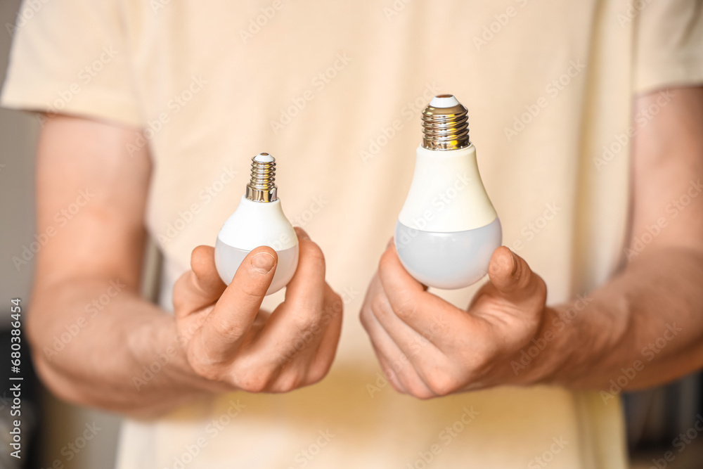 Man holding different light bulbs at home, closeup