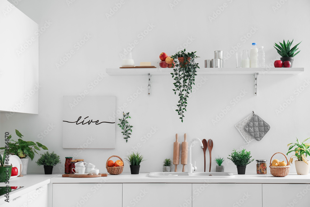 White counter and shelf with different kitchen utensils