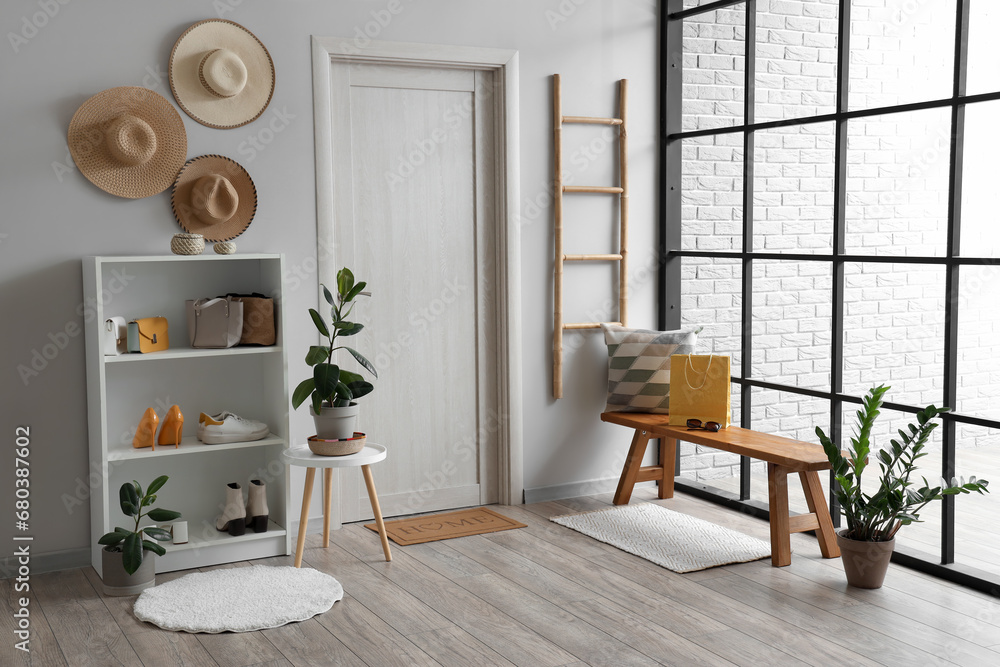 Interior of modern hallway with wooden bench and houseplants